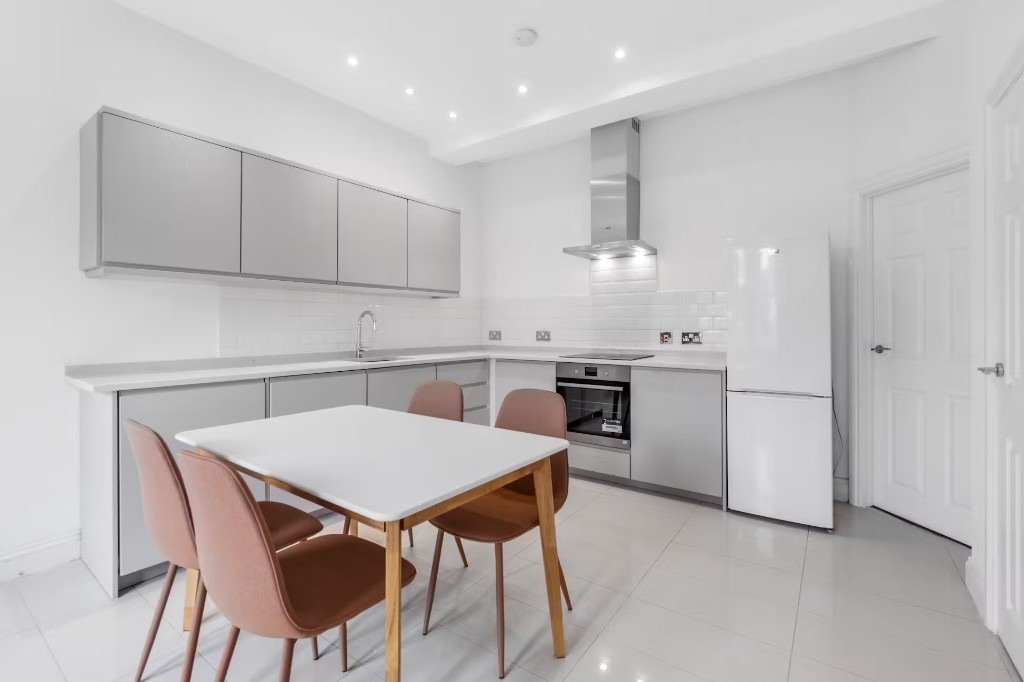 A modern kitchen-diner with a full-height fridge-freezer beside the oven